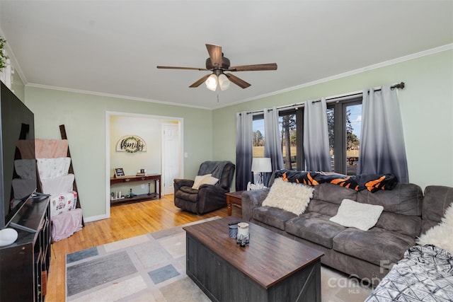 living room featuring light hardwood / wood-style flooring, ceiling fan, and crown molding