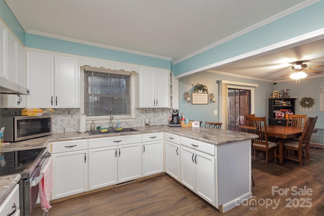 kitchen with kitchen peninsula, backsplash, stainless steel appliances, sink, and white cabinets