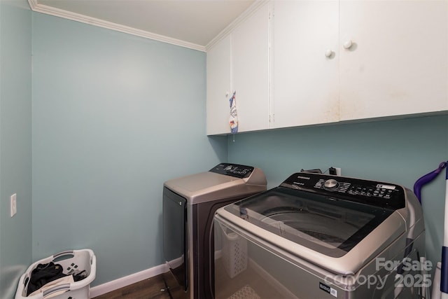 laundry area featuring cabinets, dark hardwood / wood-style flooring, washing machine and dryer, and crown molding