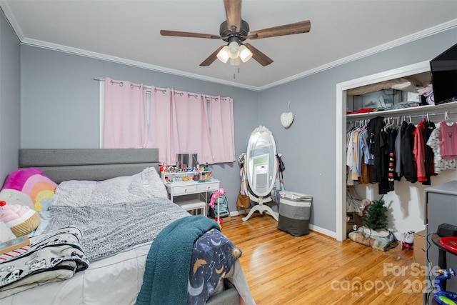 bedroom featuring crown molding, ceiling fan, a closet, and hardwood / wood-style floors