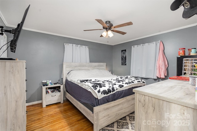 bedroom featuring hardwood / wood-style flooring, ceiling fan, and crown molding