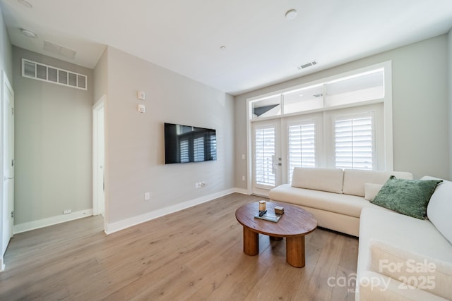 living room featuring french doors and light wood-type flooring