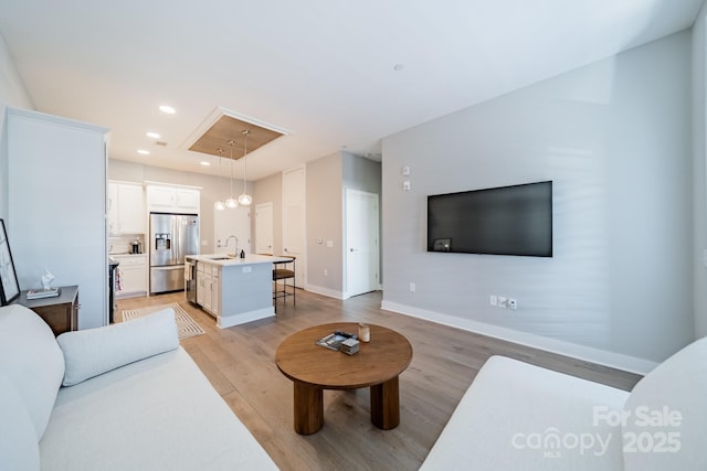 living room featuring light hardwood / wood-style flooring and sink