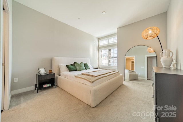 bedroom with light carpet and a high ceiling