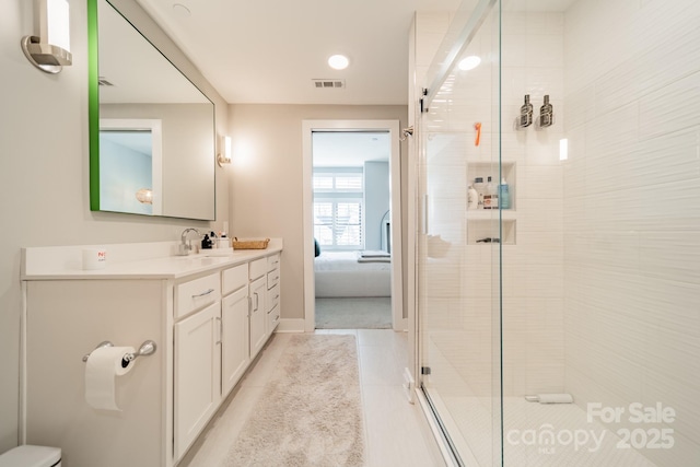 bathroom featuring tile patterned flooring, vanity, and a shower with shower door