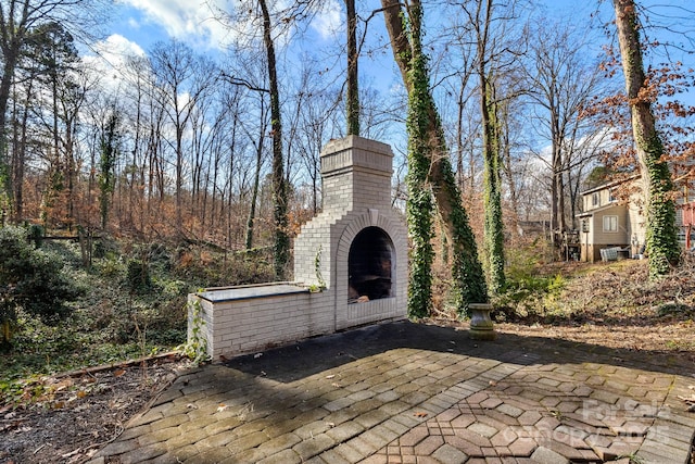 view of patio with an outdoor brick fireplace