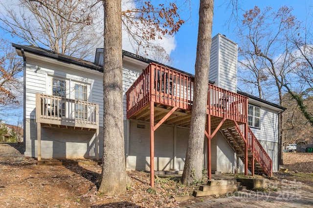 rear view of house featuring a wooden deck