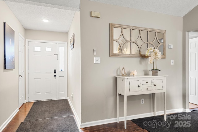 foyer featuring dark hardwood / wood-style flooring and a textured ceiling