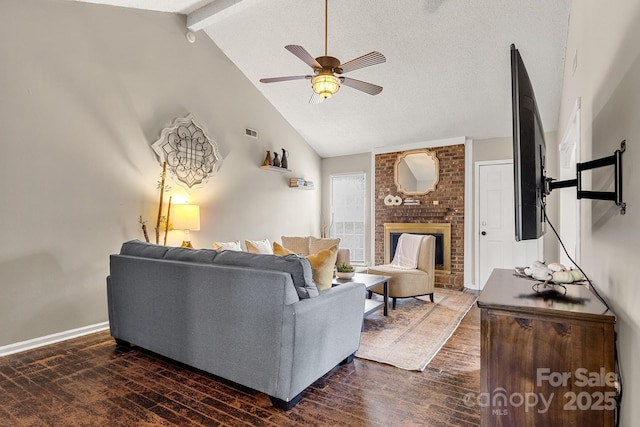 living room featuring dark wood-type flooring, ceiling fan, a fireplace, a textured ceiling, and beamed ceiling