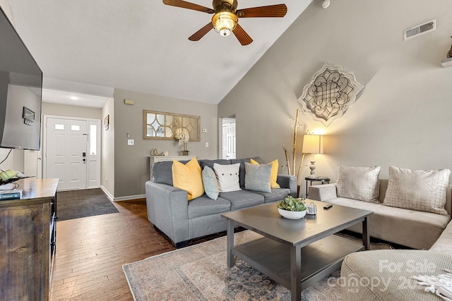 living room with high vaulted ceiling, ceiling fan, and dark wood-type flooring