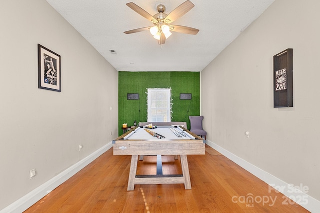 game room with ceiling fan, hardwood / wood-style floors, a textured ceiling, and billiards