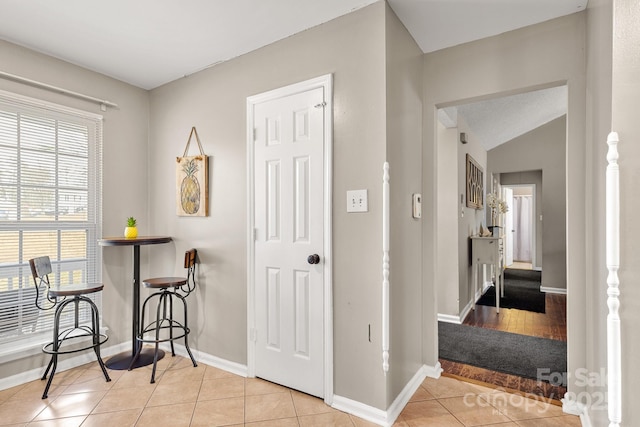 interior space featuring vaulted ceiling and light tile patterned flooring