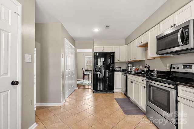 kitchen featuring white cabinets, sink, light tile patterned flooring, and stainless steel appliances