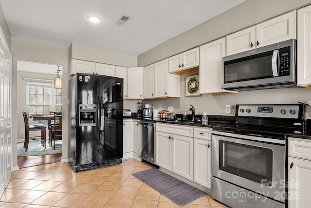 kitchen featuring light tile patterned flooring, sink, white cabinets, and stainless steel appliances