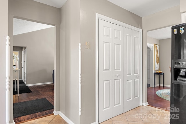 hall featuring light tile patterned floors and a textured ceiling