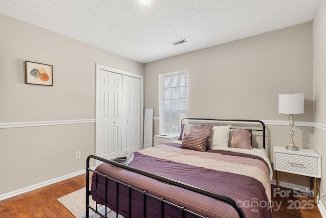 bedroom featuring a closet, hardwood / wood-style floors, and a textured ceiling