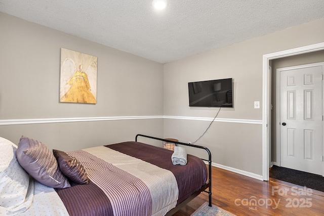 bedroom featuring a textured ceiling and dark hardwood / wood-style floors