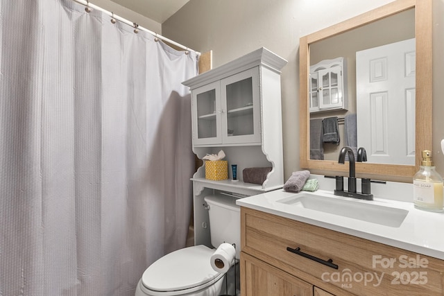 bathroom with vanity, a shower with shower curtain, and toilet