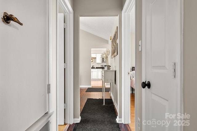 hall with a textured ceiling and lofted ceiling