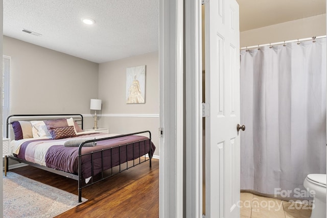 bedroom with wood-type flooring and a textured ceiling