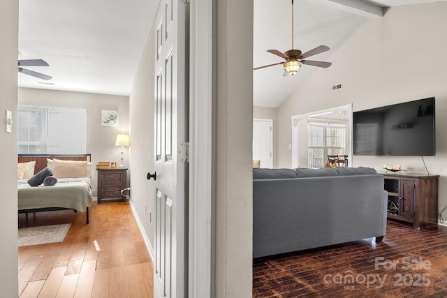 interior space with lofted ceiling with beams, ceiling fan, and dark wood-type flooring