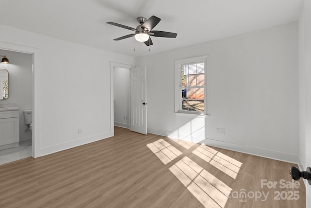 unfurnished bedroom featuring connected bathroom, light hardwood / wood-style flooring, and ceiling fan