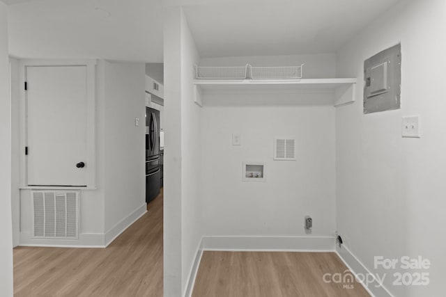 laundry room featuring electric panel, hookup for a washing machine, and light hardwood / wood-style flooring