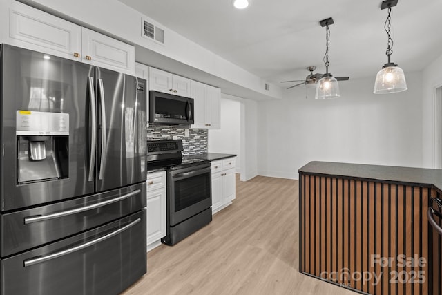 kitchen with white cabinets, light hardwood / wood-style floors, backsplash, and appliances with stainless steel finishes