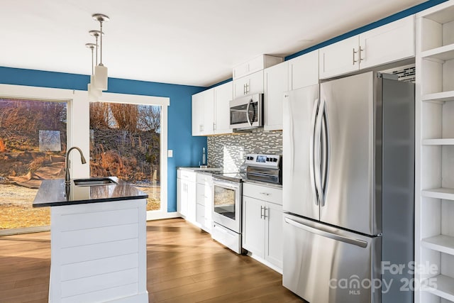 kitchen with white cabinetry, sink, stainless steel appliances, tasteful backsplash, and decorative light fixtures