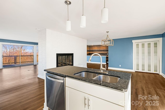 kitchen featuring white cabinetry, dishwasher, sink, dark stone countertops, and decorative light fixtures