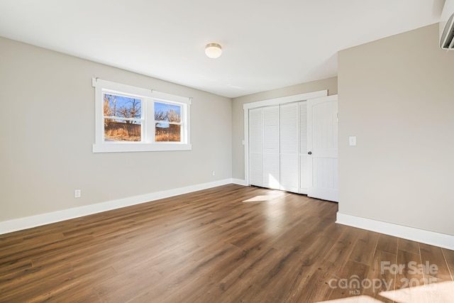 unfurnished bedroom with dark hardwood / wood-style floors and a closet