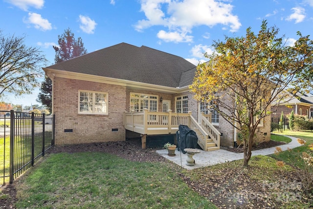 back of house with a lawn and a deck