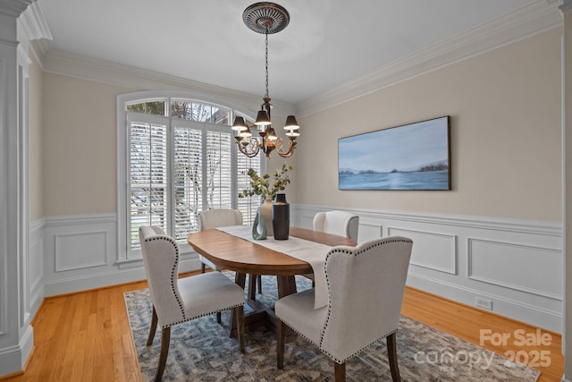 dining area with a chandelier, light hardwood / wood-style flooring, and ornamental molding