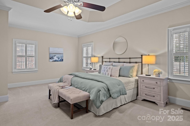 carpeted bedroom featuring ceiling fan, crown molding, and a tray ceiling