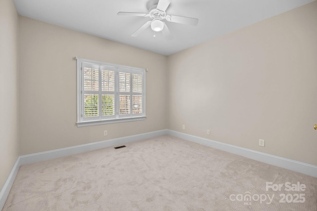 empty room featuring ceiling fan and light carpet