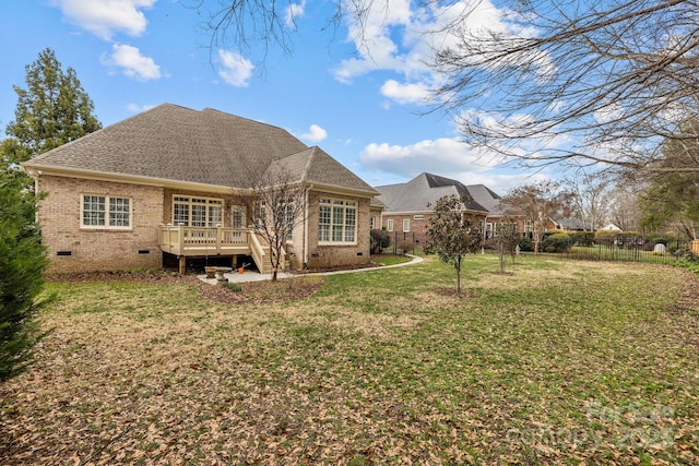 rear view of property featuring a lawn and a deck