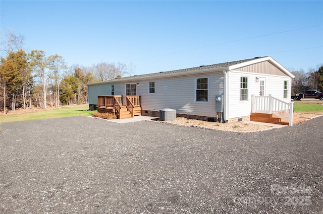 rear view of house featuring a deck and central AC