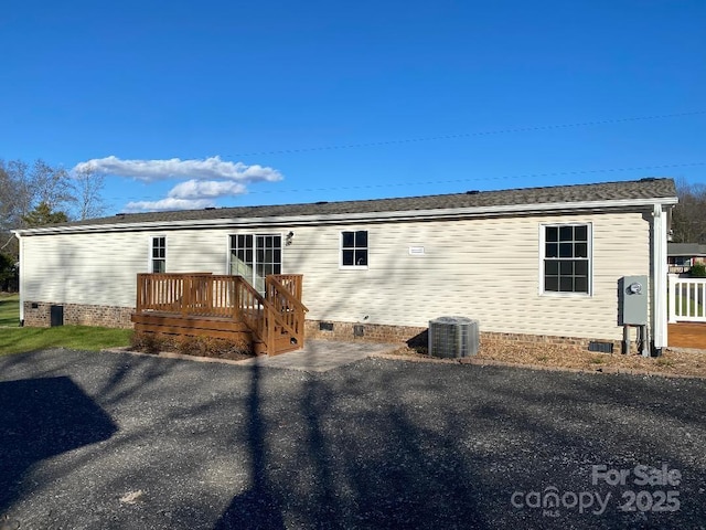 rear view of house with cooling unit and a wooden deck