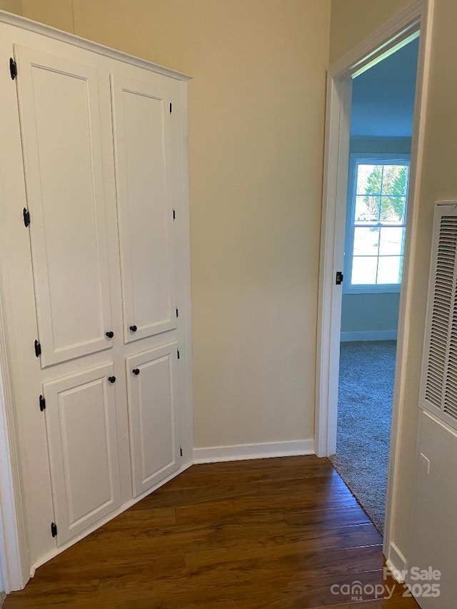 corridor with dark hardwood / wood-style flooring