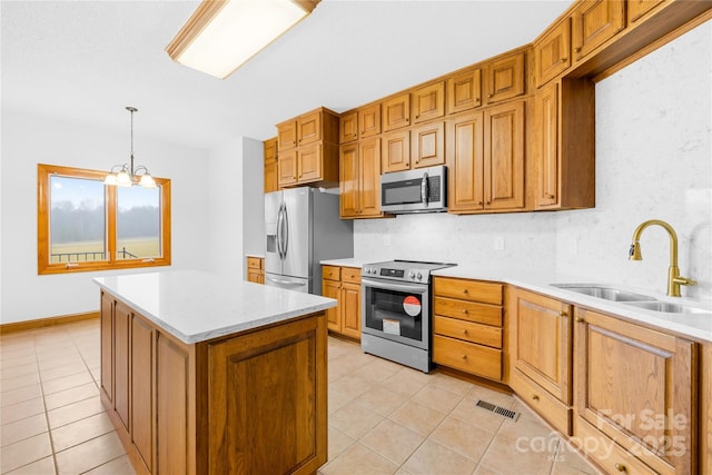 kitchen featuring tasteful backsplash, stainless steel appliances, decorative light fixtures, light tile patterned flooring, and sink