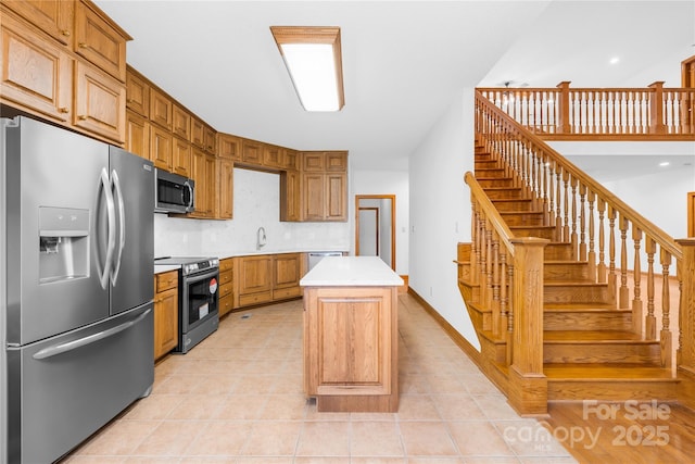 kitchen with appliances with stainless steel finishes, light tile patterned floors, tasteful backsplash, a kitchen island, and sink