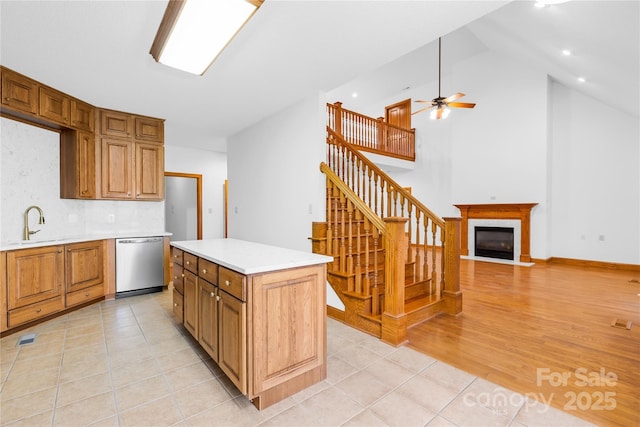 kitchen with light tile patterned flooring, a kitchen island, dishwasher, and tasteful backsplash