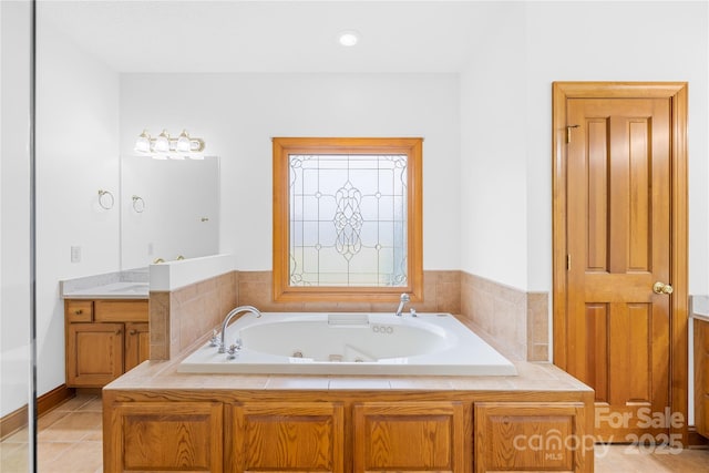 bathroom with tile patterned floors, vanity, and a relaxing tiled tub