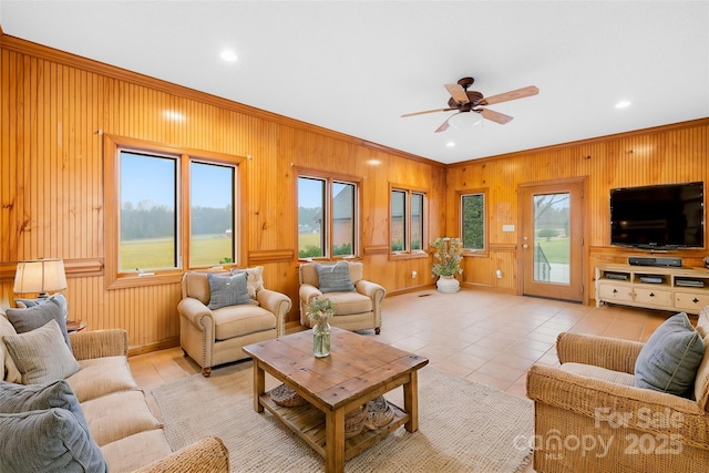 living room featuring ceiling fan, plenty of natural light, crown molding, and light tile patterned floors