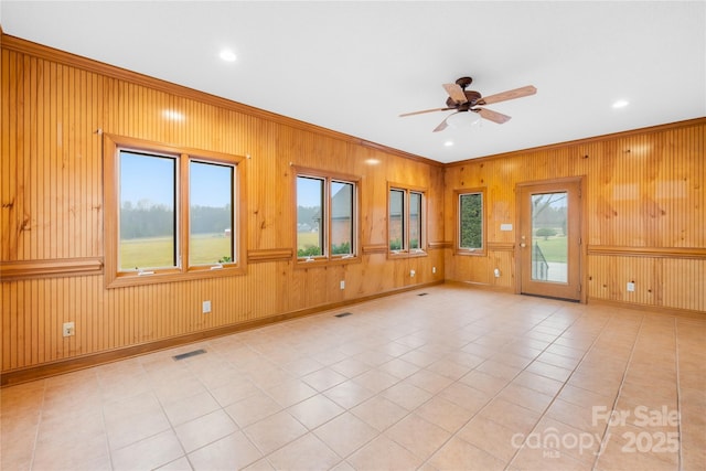 tiled spare room with ceiling fan and crown molding