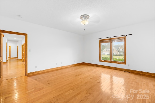 unfurnished room with light wood-type flooring and ceiling fan