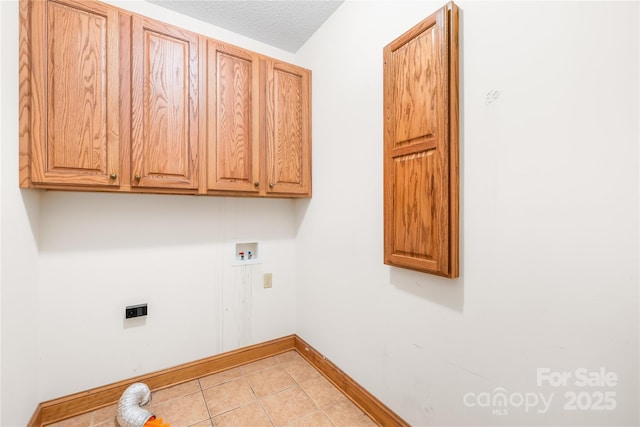 laundry area with a textured ceiling, cabinets, washer hookup, and light tile patterned floors