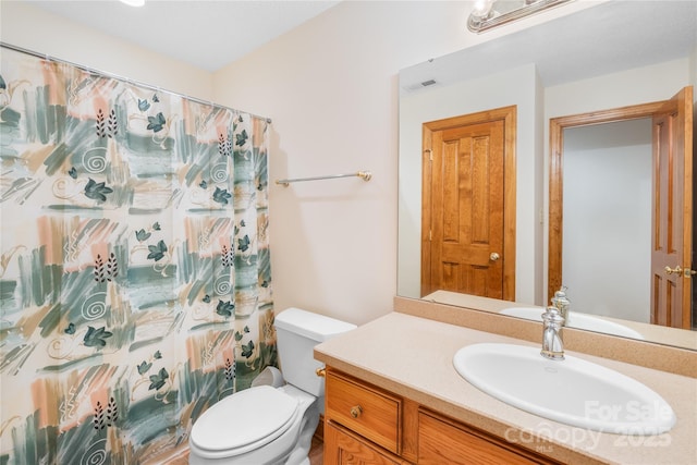 bathroom with curtained shower, vanity, and toilet