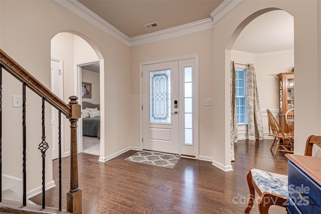 entrance foyer featuring crown molding, dark hardwood / wood-style flooring, and a healthy amount of sunlight