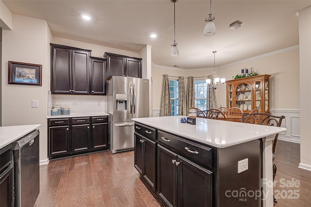 kitchen featuring tasteful backsplash, stainless steel appliances, dark hardwood / wood-style floors, a kitchen island, and hanging light fixtures